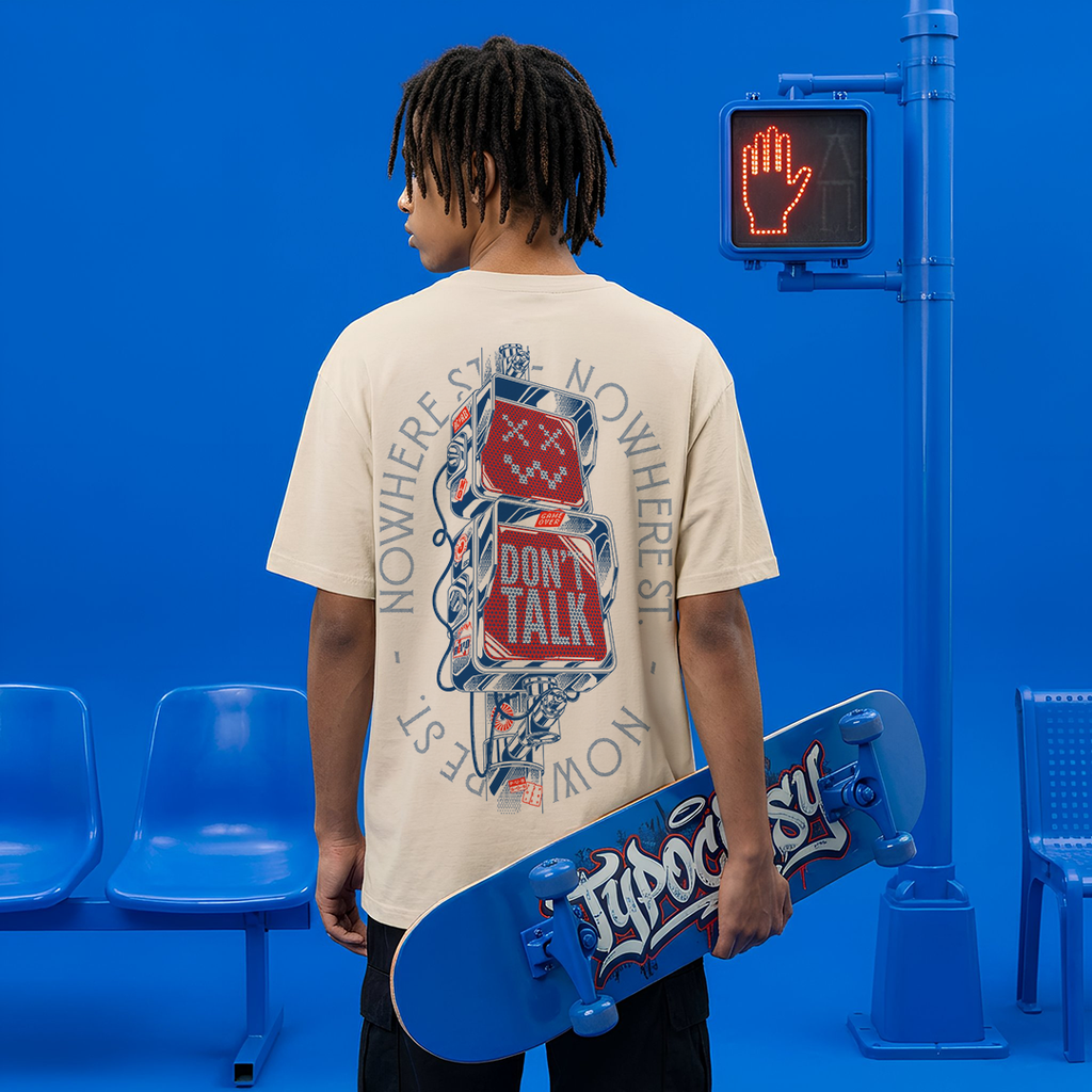 Person holding a skateboard with a blue background and a traffic light displaying a hand symbol.