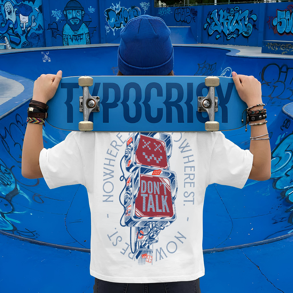 Person holding a skateboard with 'Typhocricy' branding in front of a blue graffiti-covered wall.