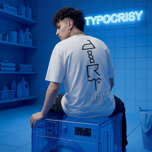 Person wearing a white t-shirt with black graphics sitting on a blue washing machine in a blue-tinted room with 'Typocrisy' neon sign.