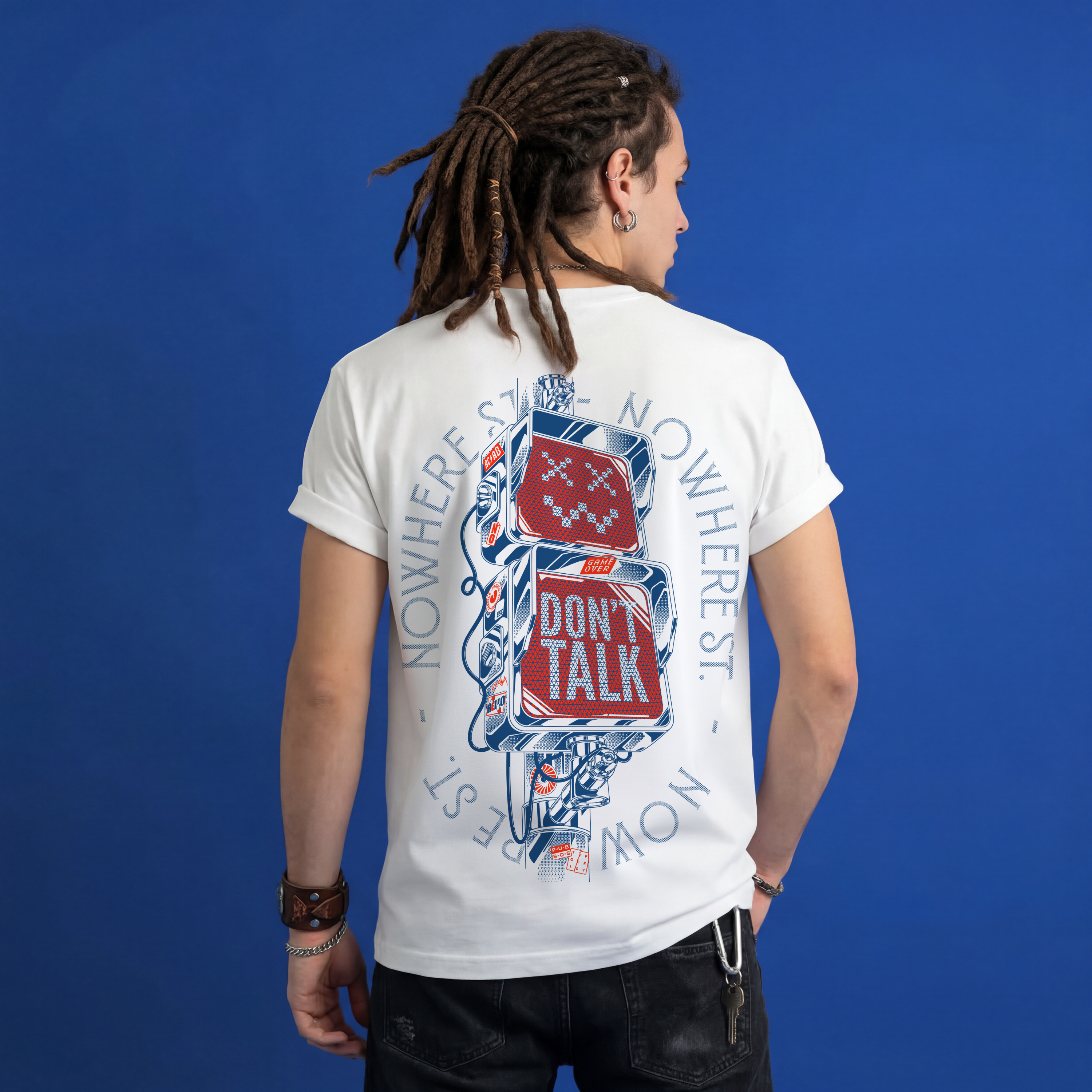 Male model with dreadlocks wearing white Typocrisy Dont Talk oversized t-shirt, back graphic, blue studio backgroun