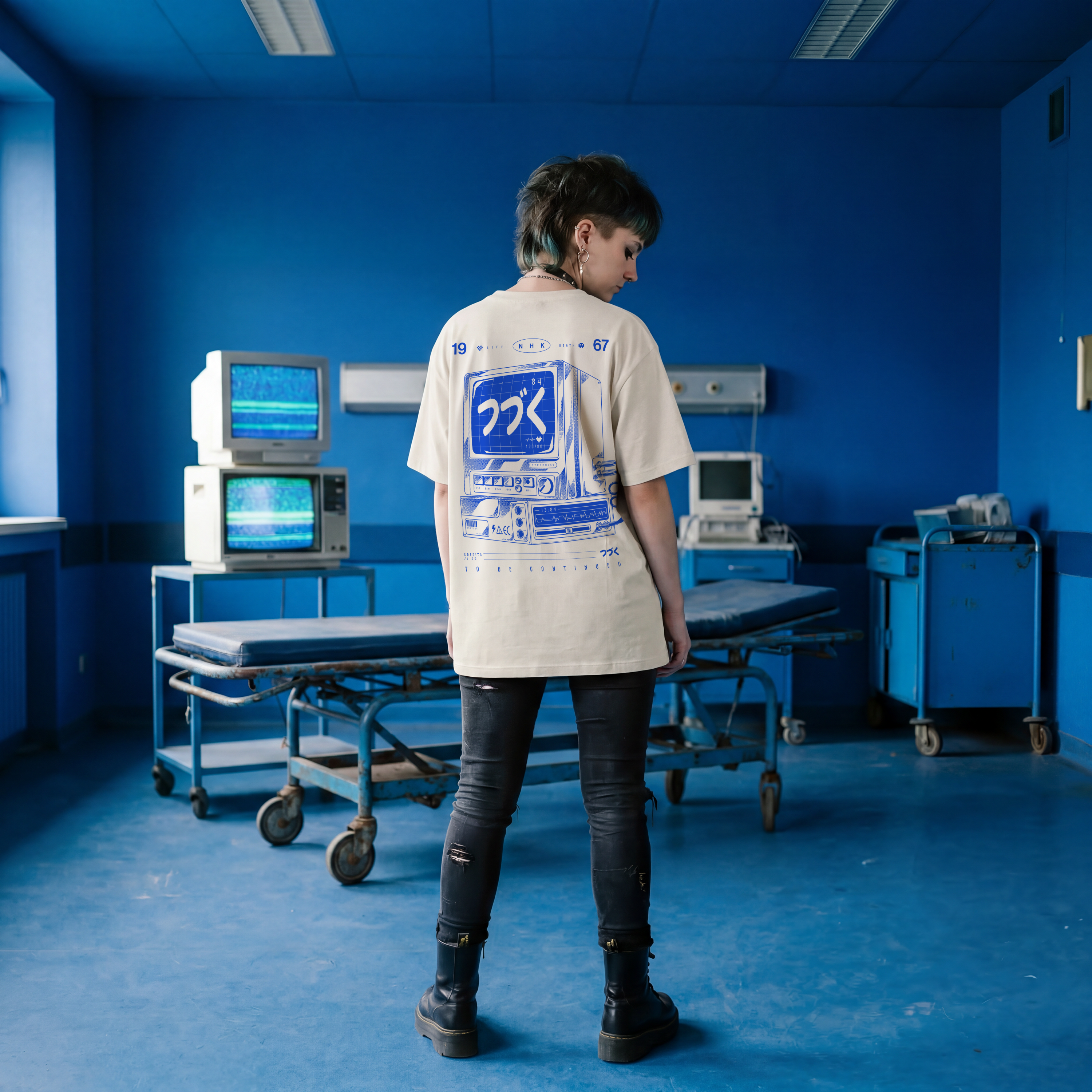 Person standing in a blue room with medical equipment and monitors