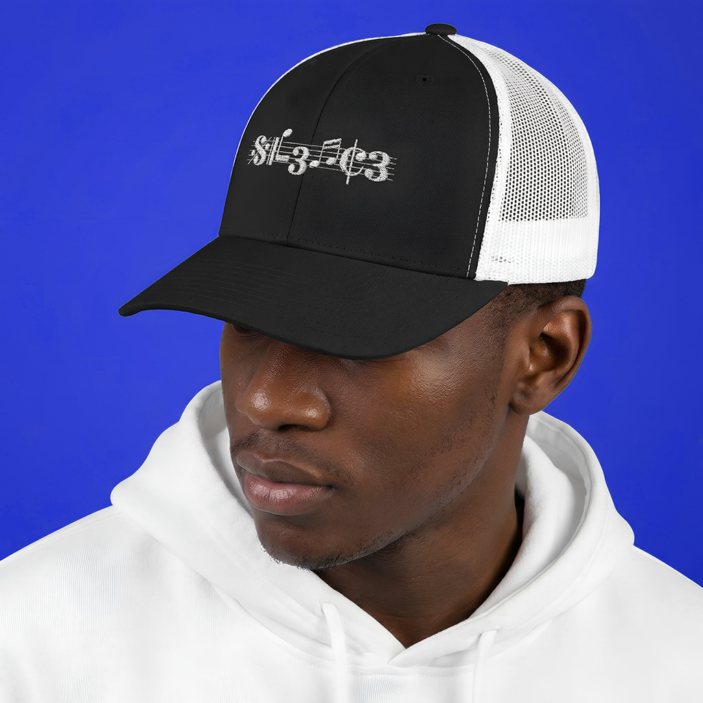 Person wearing a Typocrisy SIL3NC3 Embroidered Trucker black and white cap with text on a blue background