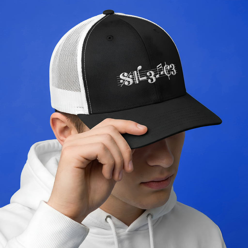 Person wearing a black and white Typocrisy SIL3NC3 Embroidered Trucker cap with text on a blue background