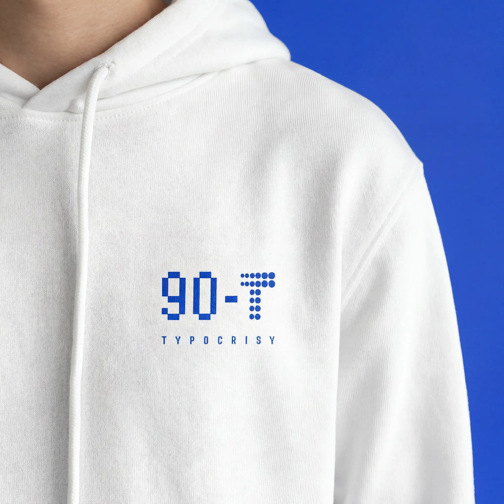 Close-up of white oversized hoodie chest with blue pixel-style 90-T logo and TYPOCRISY wordmark — front graphic detail of THE END Hoodie